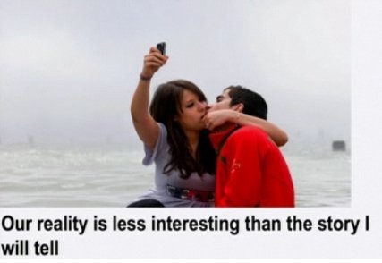two people makin' out, while one of them uses a camera phone to document the moment.