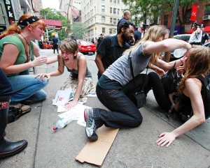 Photo of Occupy Wall Street protestors. Some were sprayed with mace, and others are helping them. 
