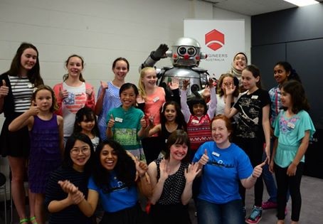 A group of young women and girls with a robot 