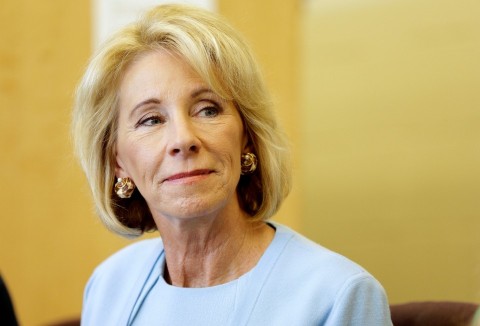 Betsy DeVos listening to a presentation during a charter school visit