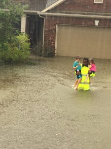 Harris County Sheriff's Deputy Rick Johnson carries two children through waist-deep flood waters in Houston, Texas