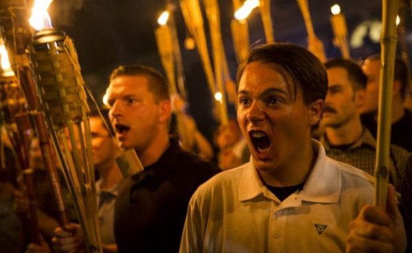 A crowd of white supremacists in polo shirts, carrying tiki torches, at a march in Charlottesville