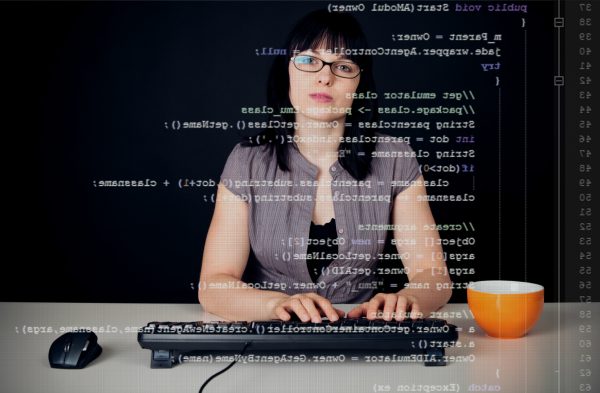 Woman sitting at computer keyboard with computer code superimposed over her face