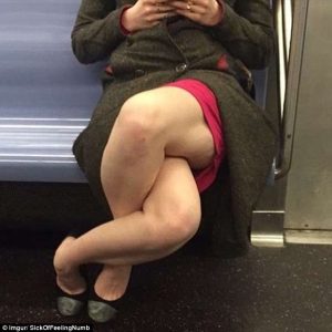 Waist-down photo of a woman on the subway with her legs crossed at the knees and ankles