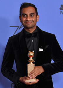 Aziz Ansari standing against a blue background after receiving the award for Best Performance by an Actor in a Television Series, Musical or Comedy at the 2018 Golden Globes
