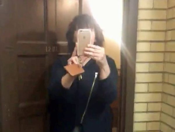 Yale student Sarah Braasch uses the camera on her phone after calling the police to report a black student napping in the dorm common room